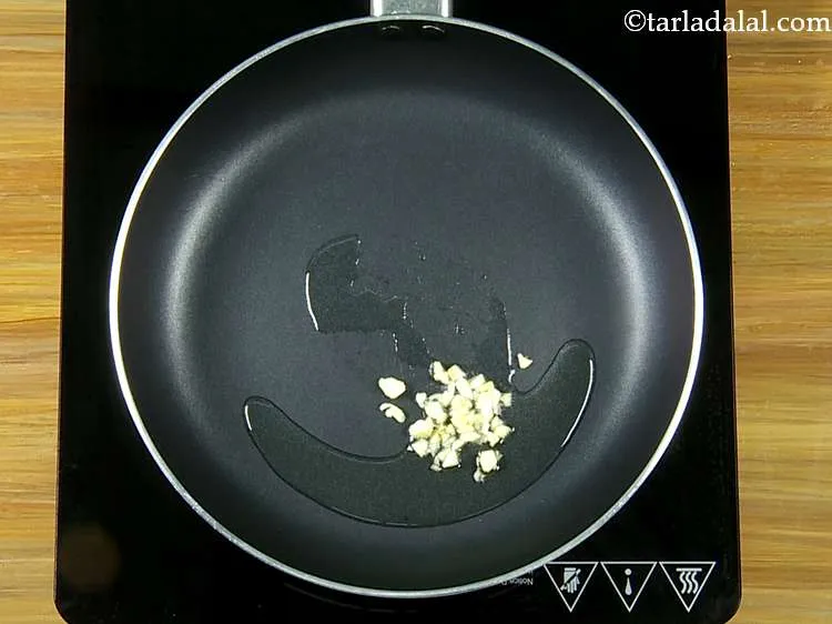 Step 25 – Heat the oil in a broad non-stick pan and add the garlic.