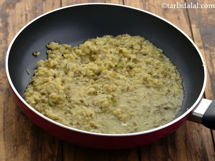 स्टेप 26 – फिर पके हुए दाल-चावल का मिश्रण डालें। खिचड़ी की स्थिरता …