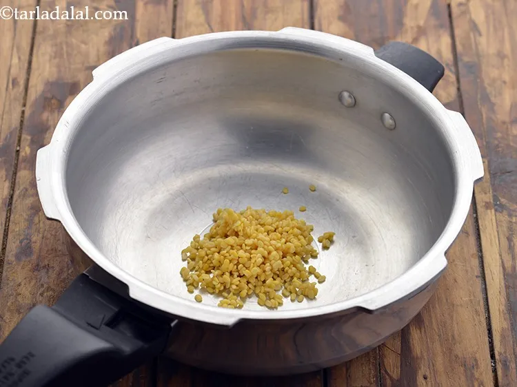 स्टेप 14 – धुली हुई पीली मूंग दाल को साफ प्रेशर कुकर में …