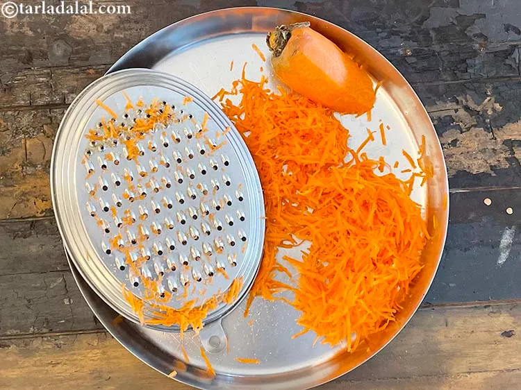 स्टेप 7 – एक ग्रेटर का उपयोग करते हुए, गाजर को कद्दूकस करें।