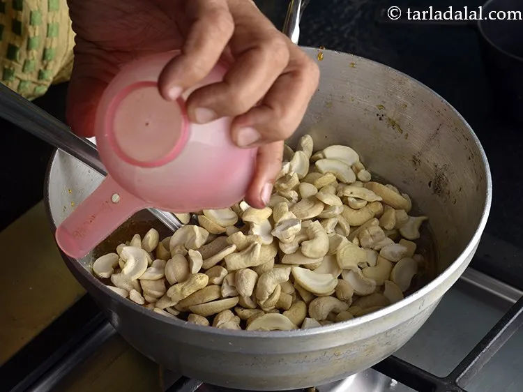 Step 9 – Immediately remove the kadhai from the flame and add the cashew nut halves. These cashew …