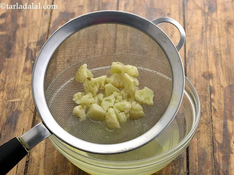 Step 12 – Drain out all the water using a strainer and discard it. Keep the blanched cauliflower …