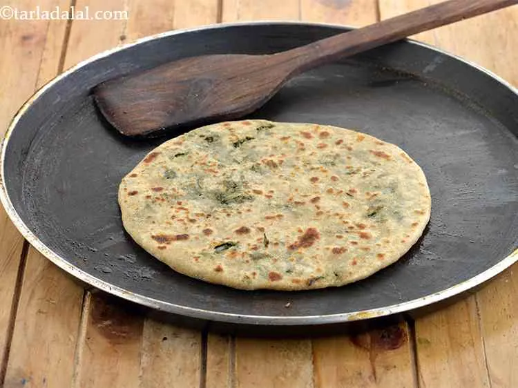 स्टेप 16 – जब बेस 1/4 पक जाए, तो पराठे को पलट दें …