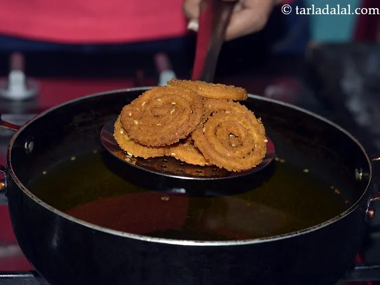 Step 23 – Flip and fry the <strong>chakri</strong> till they turn crunchy and golden brown in colour from …