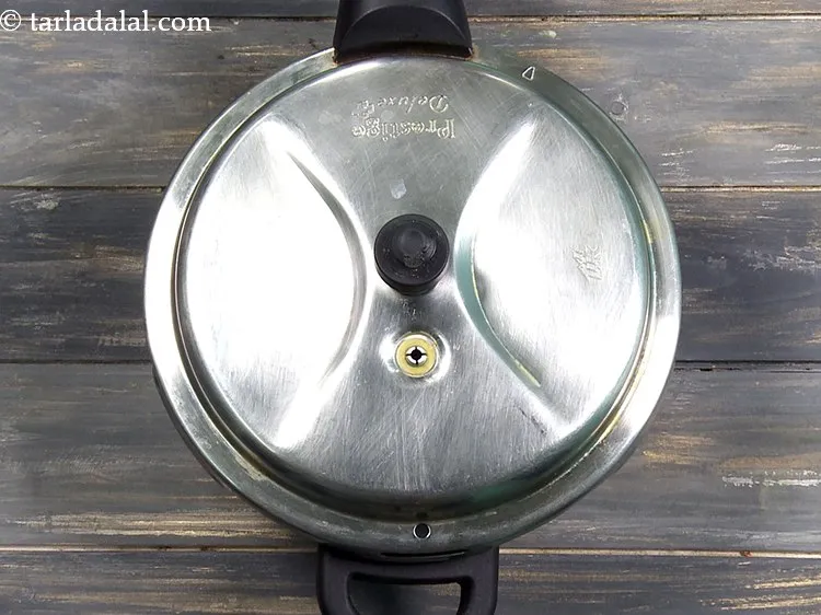 स्टेप 9 – प्रेशर कुकर का ढक्कन बंद करें और ५ सीटी के …