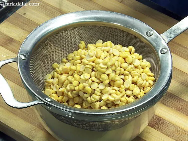 Step 5 – <div> After 2 hours, drain the chana dal using a strainer.</div> &nbsp;