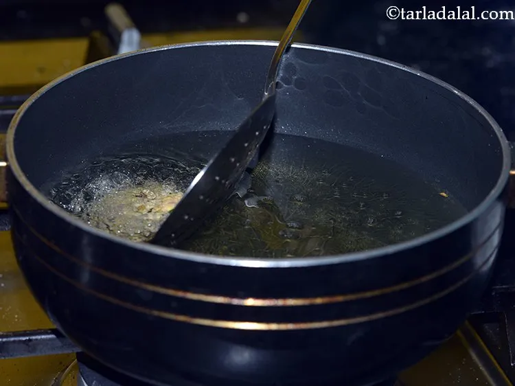 Step 20 – Slide 3-4 chana dal vada carefully. The number of vada will depend upon the size …