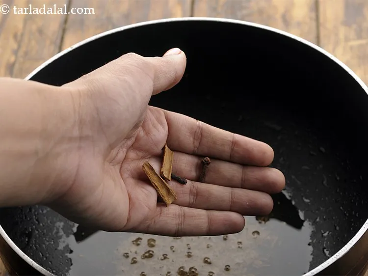 Step 14 – When the seeds crackle, add the cinnamon and cloves.