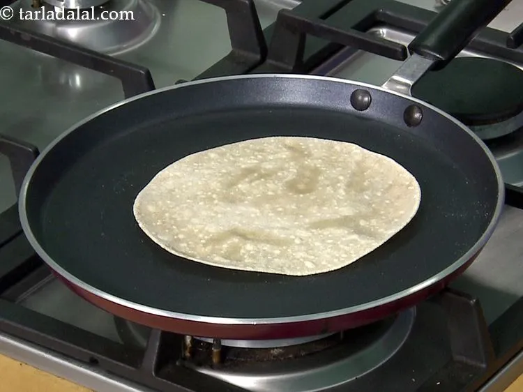 Step 26 – Put the rolled-out chapati on the tava. You need to cook it lightly till small …