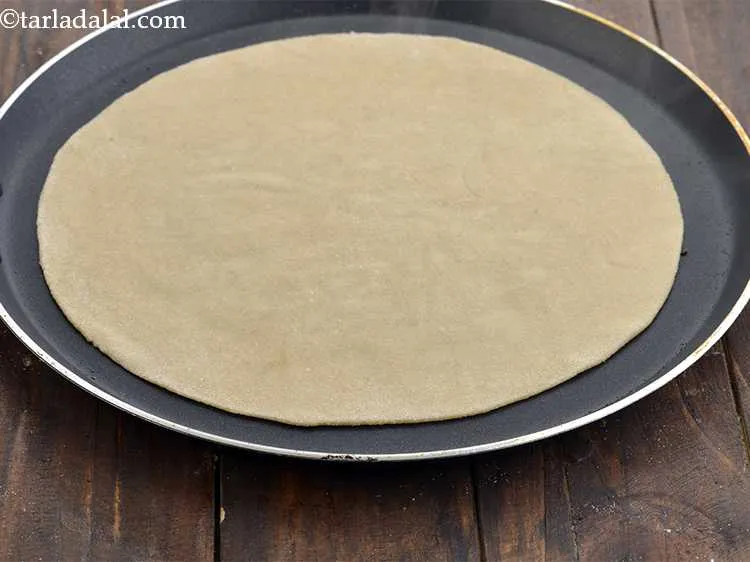 Step 14 – Put the rolled-out chapati on the tava. You need to cook it till small blisters …