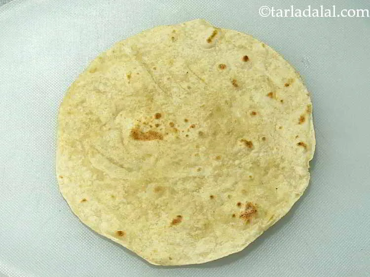Step 15 – Place a chapati on a clean, dry surface. To learn how to make it, check …