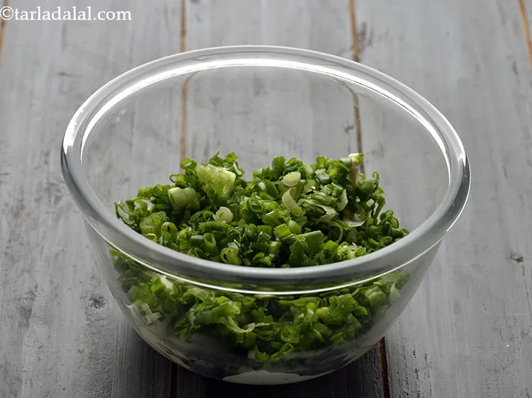 स्टेप 2 – बारीक कटे हुए हरे प्याज डालें। हम हरे प्याज का …