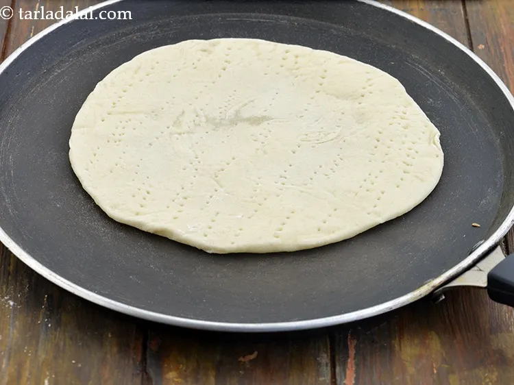 Step 23 – Place it on a non-stick tawa (griddle) and cook it till it is half done …