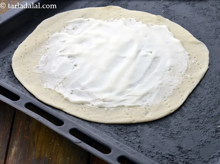 Step 25 – Spread 1 tbsp of <a href="https://www.tarladalal.com/glossary-cheese-spread-309i">cheese spread</a>&nbsp;evenly on the rolled and pricked dough leaving a …