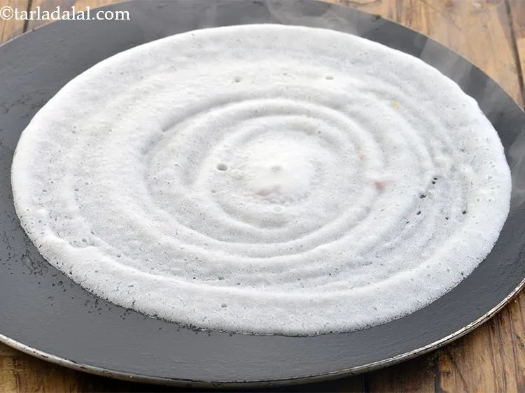 Step 7 – Spread the batter in a circular motion to make a 175 mm. (7&rdquo;) diameter thin …