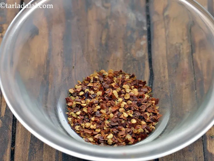 स्टेप 6 – सूखी लाल मिर्च के फ्लैकस् डालें।