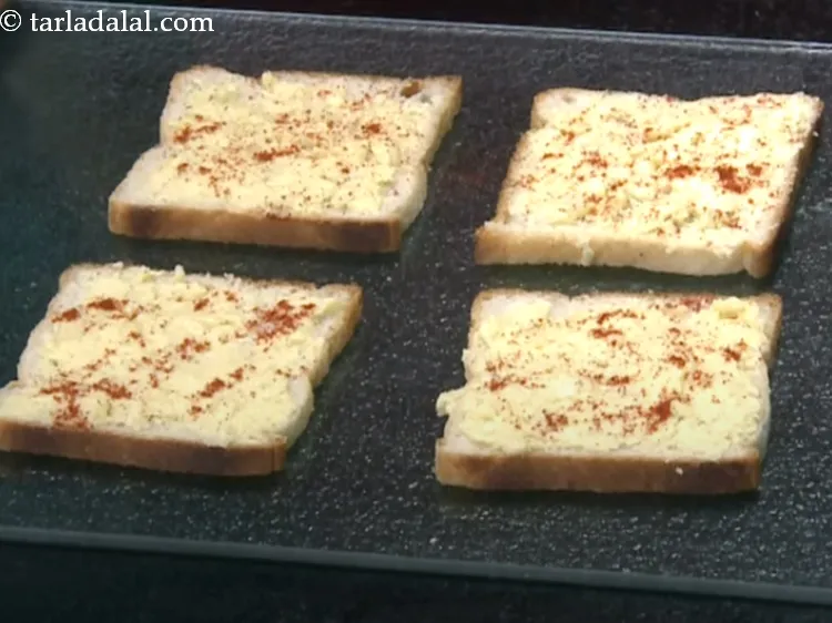 Step 16 – Sprinkle a little <a href="https://www.tarladalal.com/glossary-chilli-powder-red-chilli-powder-339i">chilli powder</a> over each bread slice.