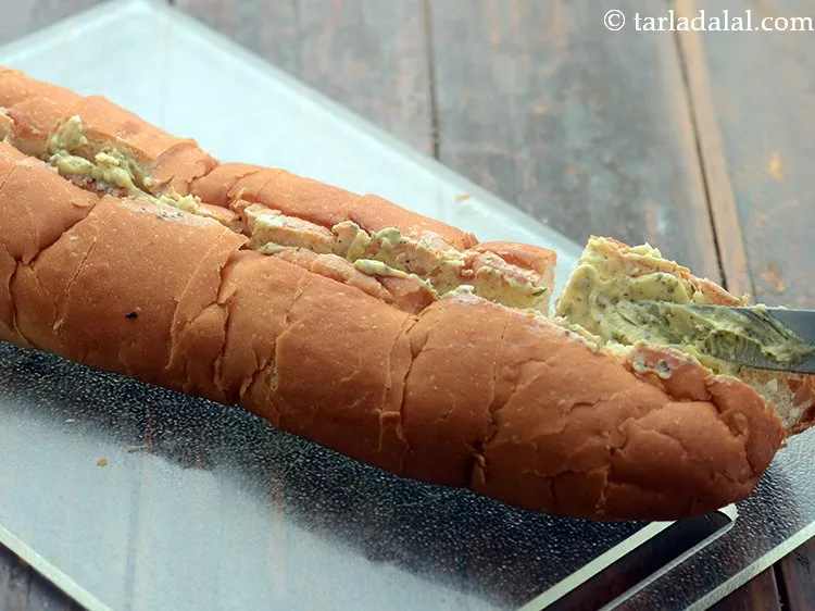 Step 9 – Also, apply the garlicky herb mixture in between the diagonal slits using a butter knife.