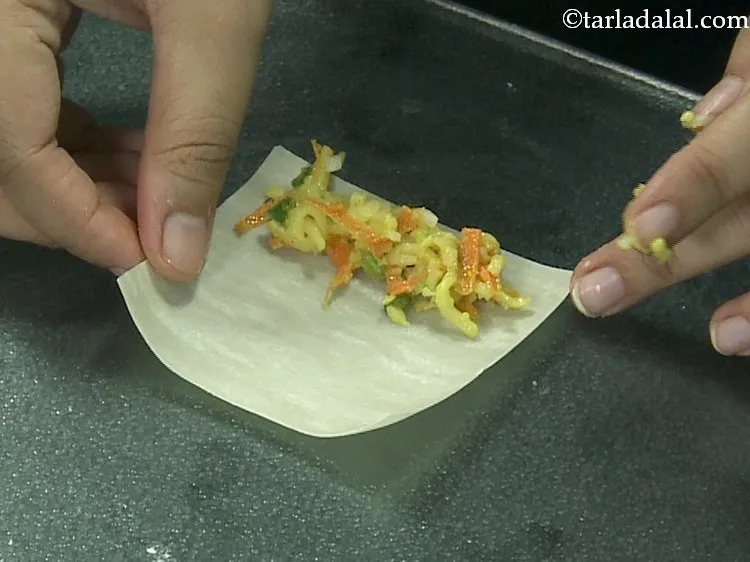 Step 17 – Place a portion of the cheesy maggi filling at one end.