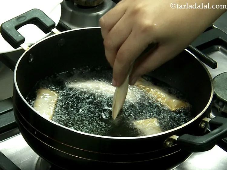 Step 21 – Heat the oil in a deep non-stick kadhai and deep-fry a few rolls at a …