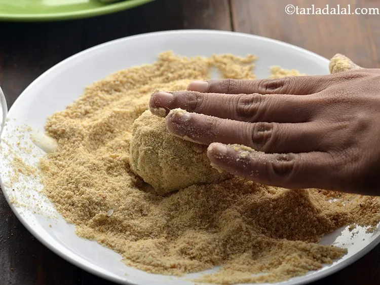 Step 22 – Thereafter, roll the <strong>Cheesy Noodle Cutlet</strong> in breadcrumbs till it is evenly coated from all …