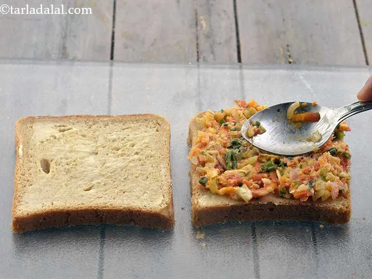 Step 18 – Take 1 portion of the prepared filling and spread evenly on one bread slice.