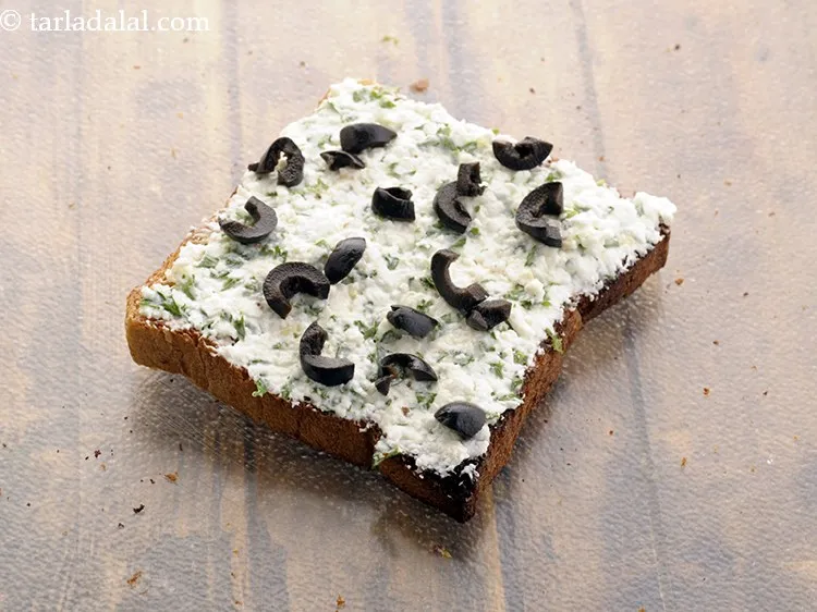 Step 10 – Garnish&nbsp;<strong>cheesy paneer parsley toast | paneer parsley cheese open toast&nbsp;|&nbsp;paneer parsley toast |</strong>&nbsp;will black olives.