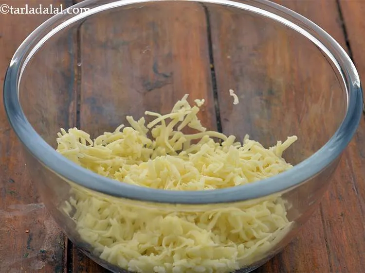 Step 11 – To make the potato cheese balls mixture, in a deep bowl take the grated cheese.