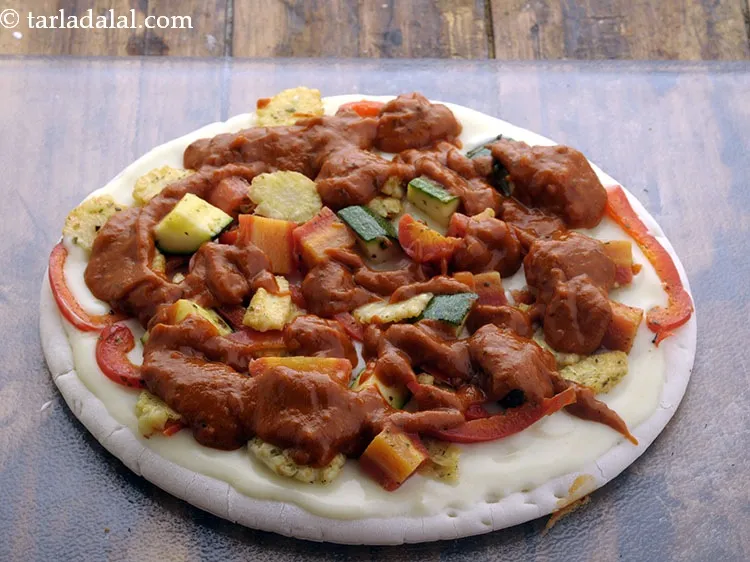 Step 26 – Spread &frac14; cup of pizza sauce evenly over it.