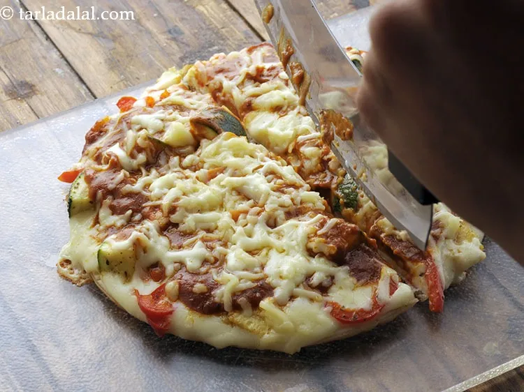Step 37 – Cut&nbsp;<strong>&nbsp;cheese veggie pizza on tava </strong>&nbsp;into equal wedges and serve immediately.