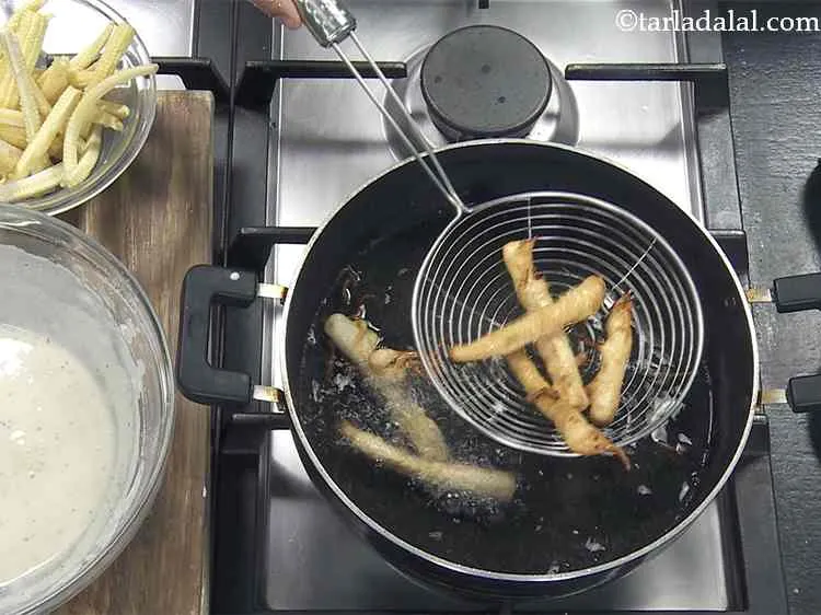 Step 11 – Heat the oil in a deep non-stick pan and dip a few baby corn pieces …