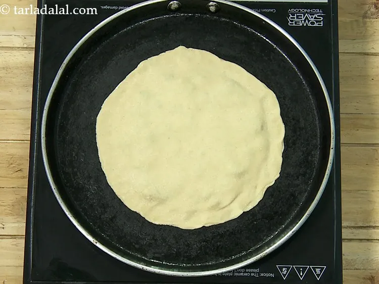 Step 23 – Heat a non-stick tava (griddle) and place the paratha.