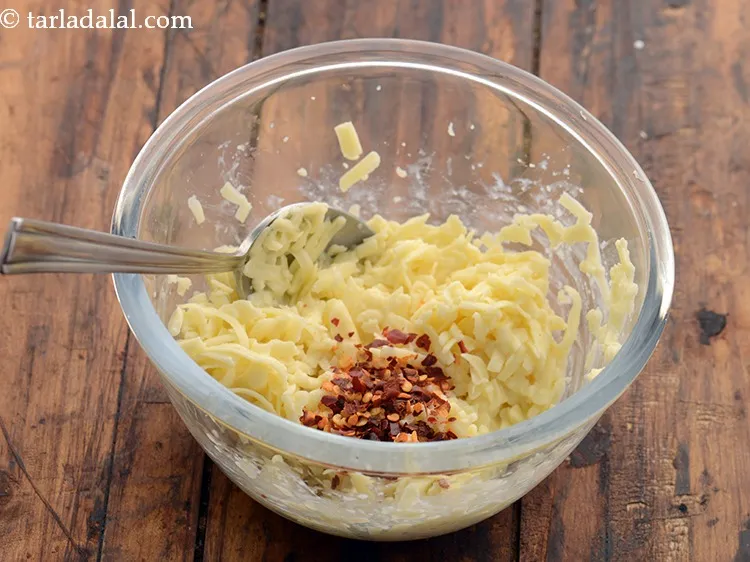 स्टेप 7 – सरसों का पाउडर और सूखी लाल मिर्च के फ्लैकस् डालें।