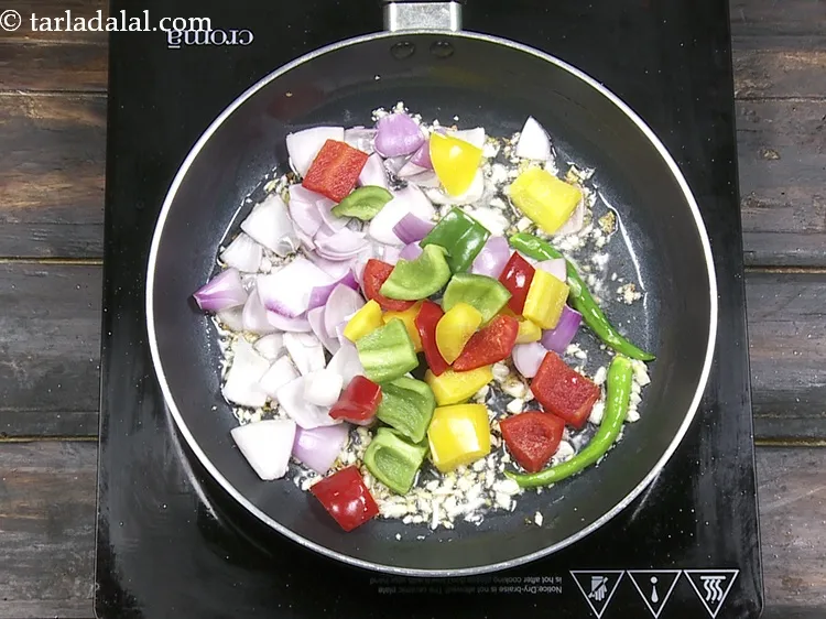 Step 35 – Add 1/2 cup&nbsp;coloured&nbsp;<a href="https://www.tarladalal.com/glossary-capsicum-cubes-170i">capsicum cubes</a>.