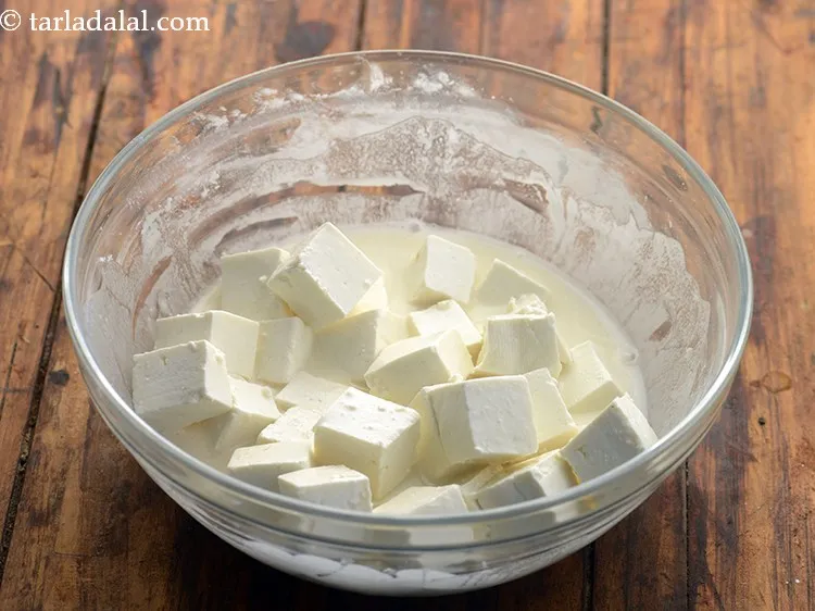 स्टेप 7 – <a href=""https://www.tarladalal.com/glossary-paneer-cubes-cottage-cheese-cubes-hindi-1002i"">पनीर के क्यूब्स</a> को तैयार घोल में डालें।