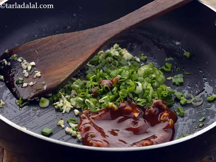Step 21 – Add the tomato ketchup. It provides a tangy flavor to the potato chilli.