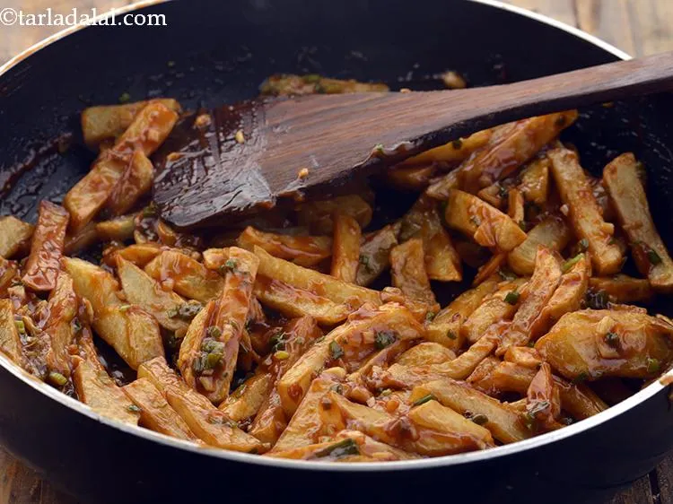 Step 28 – Toss the <strong>Chilli Potato,&nbsp;</strong><strong>( Chinese Chilli Potatoe)</strong>&nbsp;gently and cook on a high flame for 1 …
