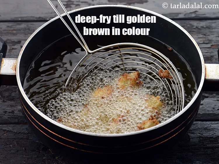 Step 13 – When the <strong>Chinese pakodas</strong> have turned light brown in color from one side, gently flip …