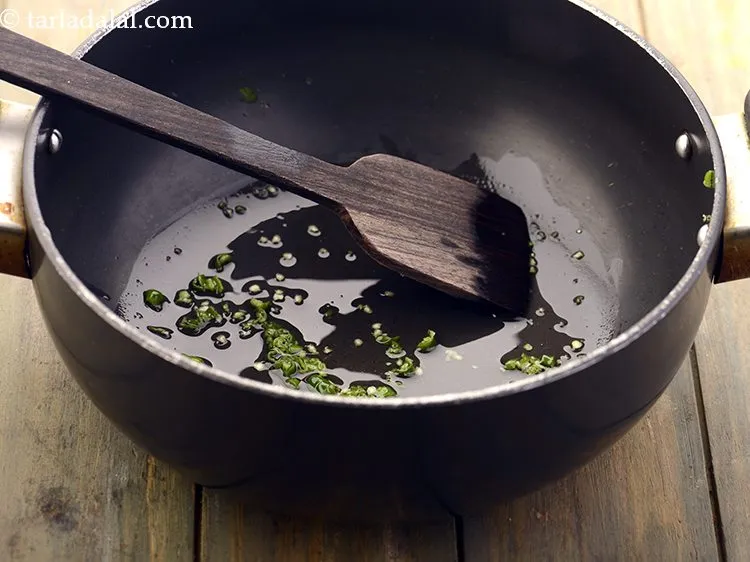 स्टेप 6 – तेल गरम होने के बाद, हरी मिर्च डालें और तेज …