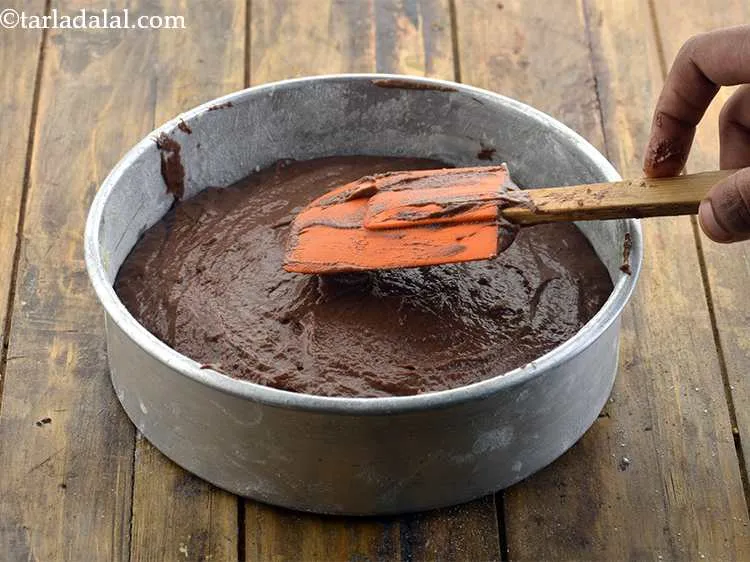Step 11 – Now, put the&nbsp;<strong>Eggless Chocolate cake using curds</strong><strong>&nbsp;</strong>batter into this baking tin. Spread evenly with a …