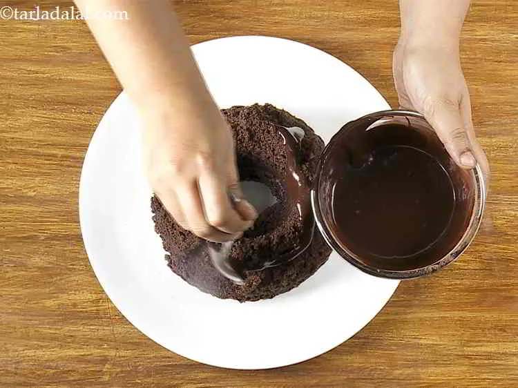 Step 26 – Pour this icing generously over the cooled&nbsp;<strong>Eggless</strong>&nbsp;<strong>Chocolate Fudge Cake</strong>.