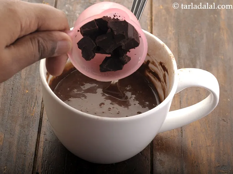 स्टेप 10 – डार्क चॉकलेट डालें। यह चॉकलेट मग केक के स्वाद को …