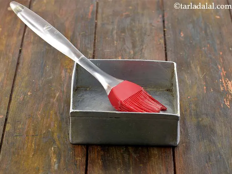 Step 9 – Grease a 100 mm. &times; 100 mm. (4&rdquo; &times; 4&rdquo;) square aluminium tin with butter.