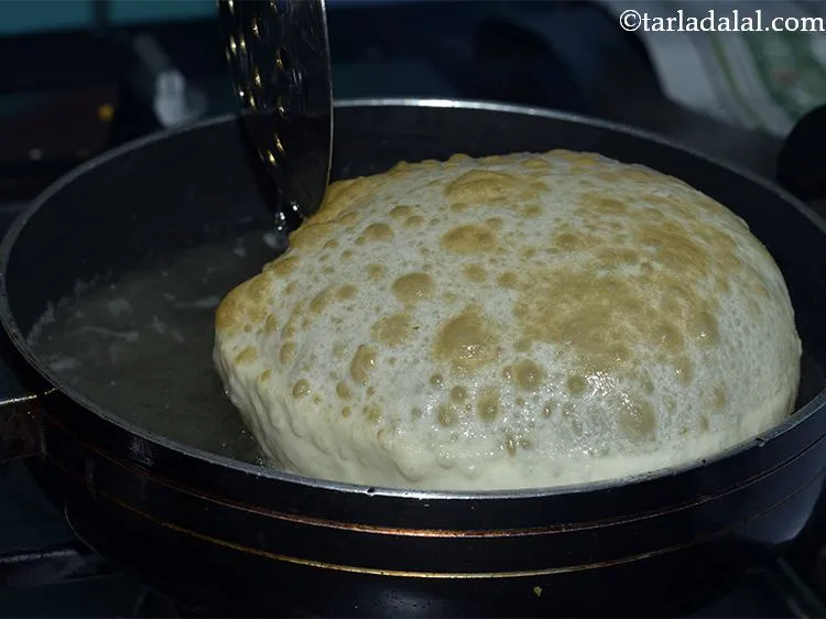 Step 10 – Heat the oil in a deep non-stick pan, deep-fry the<strong> aloo bhatura</strong> one at time …