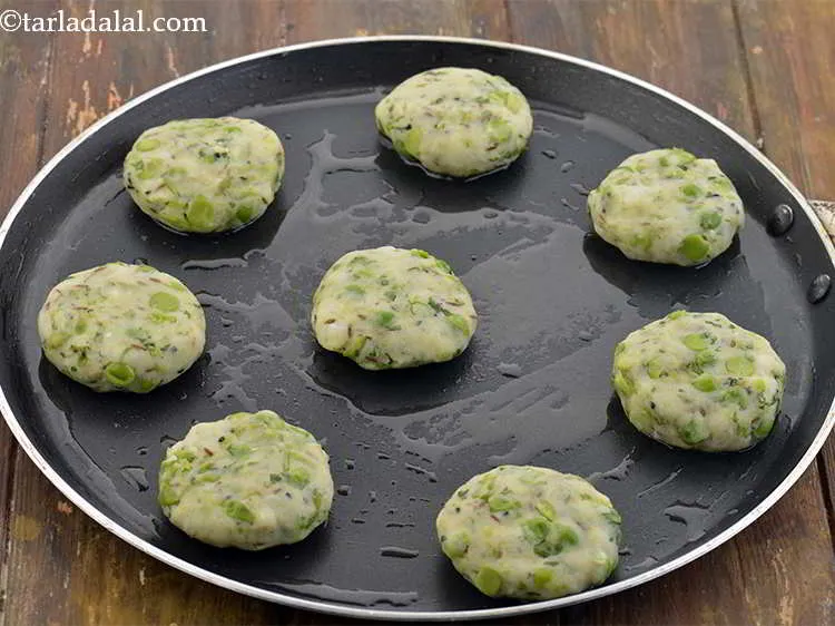 Step 39 – Place the tikkis, one by one, on it and cook on a medium flame on …