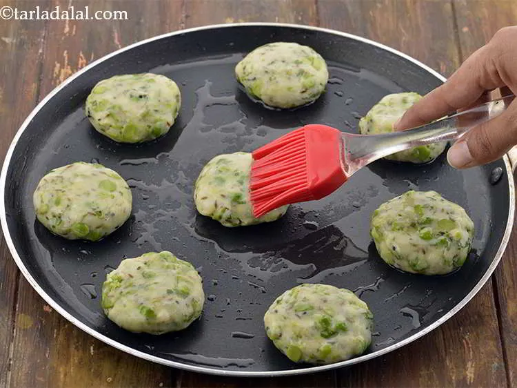 स्टेप 39 – टिक्कियों के उपर पर १ टेबल-स्पून तेल से ब्रश करें।