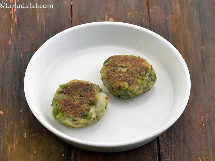 Step 42 – Just before serving, reheat the chole. Place 2 tikkis on a serving plate.