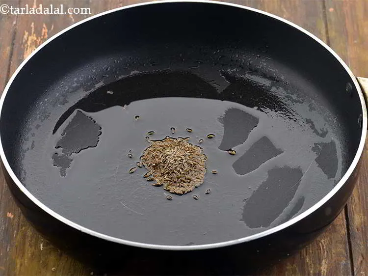 Step 22 – Heat the oil in a broad non-stick pan and add the cumin seeds.