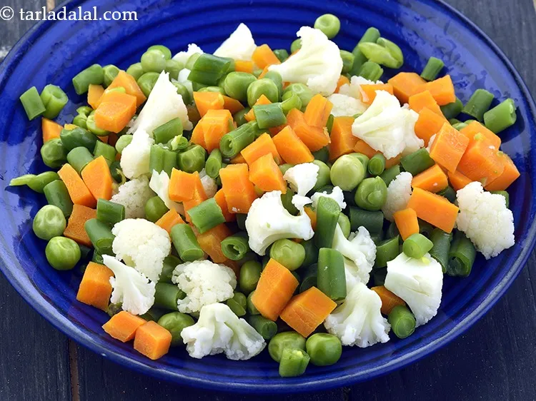 Step 10 – Add 1/2 cup&nbsp;finely&nbsp;<a href="https://www.tarladalal.com/glossary-chopped-mixed-vegetables-782i">chopped mixed vegetables</a>&nbsp;(carrot , French beans and green peas).