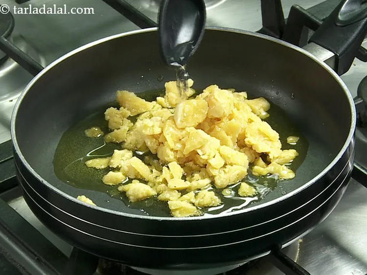 स्टेप 25 – साथ ही, १ टेबल-स्पून पानी डालें। यह गुड़ को तोड़ने …